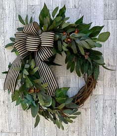 a wreath with leaves and berries hanging on a wall