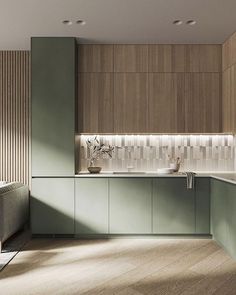 a modern kitchen with green cabinets and wood flooring, along with a white sink