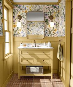 a bathroom with yellow walls and floral wallpaper on the walls, along with two sinks