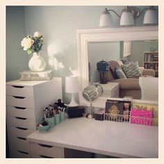 a white desk topped with a mirror and lots of drawers