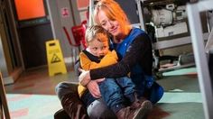 a woman sitting on the floor holding a child