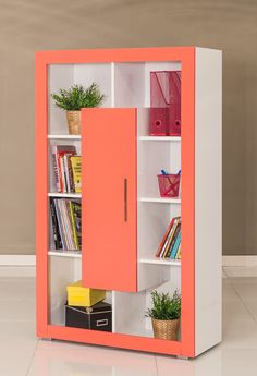 an orange and white bookcase with books on it's shelves next to a potted plant