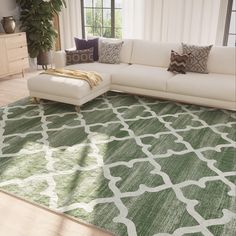 a living room with a large green rug on the floor and a white sectional couch