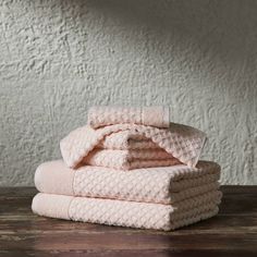 a stack of pink towels on top of a wooden table