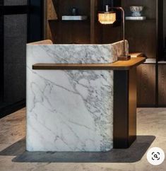 a white marble counter top sitting inside of a kitchen next to a wooden shelf and cabinets