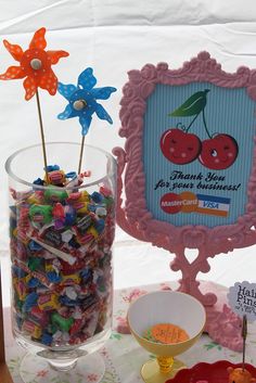 there are candy and candies in the vase on the table next to the sign