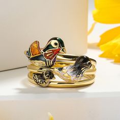 Mandarin ducks are believed to be faithful to their partner and are symbols of love, affection and loyalty. In Feng Shui, they are considered a symbol of love and marriage and are referred to as a pair of lovebirds. Crafted in gold tone sterling silver with multi-colored enamel, this ring features papa duck, mama duck and baby duck happily outing together. Add this beautiful piece to your jewelry box and you won't be disappointed.Weight: 6 gWidth: 4 mmHeight: 5.5 mmThickness: 1.5 mmMaterial: Pla Duck Jewelry, Mandarin Ducks, Duck Family, Be Faithful, Baby Duck, Mandarin Duck, Baby Ducks, Fruit Snacks, Love Symbols