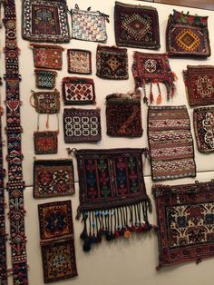 many different rugs are hanging on the wall