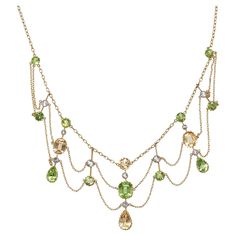 An antique, peridot, citrine, white sapphire and gold festoon necklace, with round, cushion and drop shaped faceted peridots and citrines, in gallery claw settings, and white sapphires, in millegrain edged rub over settings, in knife edge pendants, on a trace chain, with finer, trace chain festoons, with a barrel clasp, engraved with 15, for 15ct gold, with inventory number a8609 scratched on a pendant, circa 1890. Approximate Measurements: Length 388mm, longest drop 39mm Festoon Necklace Vintage, Festoon Necklace, Miss Marple, Peridot Necklace, Round Cushion, Antique Necklace, Antique Diamond, Victorian Jewelry, Inspired Jewelry