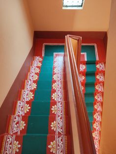 the stairs are decorated with red, green and white carpeted steps that lead up to an open skylight window