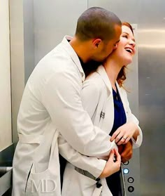 two people standing next to each other in an elevator