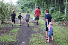 several people walking down a path in the woods