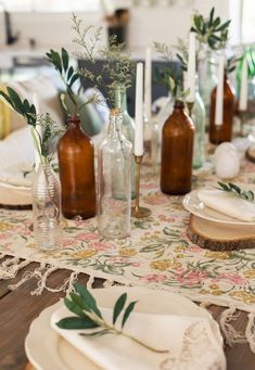 the table is set with glass bottles, plates and napkins for dinner guests to enjoy