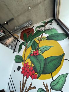 a mural painted on the side of a building with green leaves and red berries in front of a yellow sun