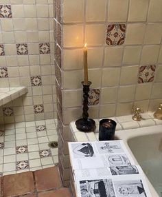 a candle sitting on top of a sink next to a bath tub in a bathroom