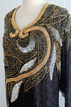 "Dramatic!  This is a beautiful gown with bold gold beading , iridescent peweter and black beading throughout.   We do not believe this dress has ever been worn.   Excellent vintage conditon.  Marked size B4 ( ? some kind of \"in house \" sizing\" Estimated size 24/26 52\" bust  52\" waist 56\" hip 54\" nape to hem  19\" shoulder  24\" sleeve 19\" circumference of sleeve Purveyor's Note: We have searched far and wide, wrestled bears, braved the cold, traversed mountain ranges, fought pirates, swam with sharks and eaten at many a questionable road side taco stand to provide our customers with one of a kind vintage pieces.  Know that whichever piece you choose to make your own has its own story and has traveled through time to get to you.  Though we strive to provide the absolute best, \"pri Elegant Party Gown With Gold Embroidery, Elegant Gown With Gold Embroidery For Gala, Elegant Gala Gown With Gold Embroidery, Gold Embellished Evening Gown, Elegant Floor-length Ballroom Evening Dress, Elegant Evening Dress With Gold Embroidery For Gala, Gold Embellished Evening Dress, Evening Floor-length Dress With Gold Embroidery, Party Dresses In Silk With Gold Embroidery