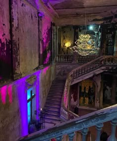 the stairs are lit up with purple and blue lights in an old building that has been converted into a nightclub