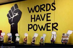 there is a sign that says words have power on the side of a wall with pictures of people holding up their fists