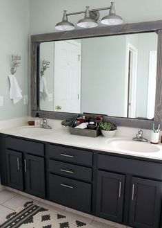 a bathroom vanity with two sinks and large mirror