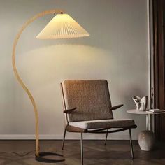 a chair with a lamp on it next to a table and floor in a room