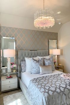 a bedroom with a chandelier hanging from the ceiling and a bed in front of it