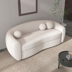 a white couch sitting on top of a carpeted floor next to a table and chair