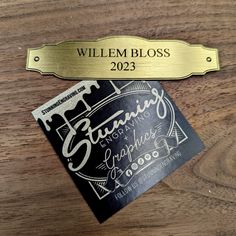 a wooden table with a metal name plate on top of it and a sign that says, william bloss