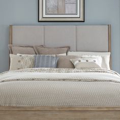 a bedroom with blue walls and a bed in the middle is decorated with pillows, blankets, and throw pillows