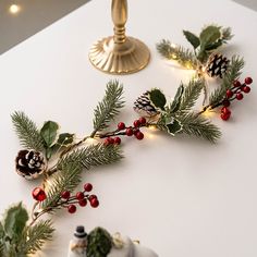 a white table topped with christmas decorations and pine cones