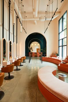 the interior of a modern restaurant with orange chairs