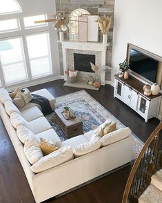 a living room filled with furniture and a flat screen tv on top of a wooden floor