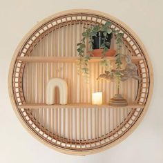 a bamboo shelf with plants and candles on it in the shape of a circular frame