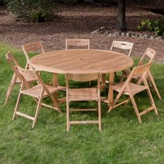 a wooden table and chairs sitting in the grass