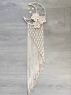 a white dream catcher hanging on the wall next to a wooden floor with stars and flowers