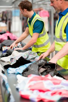 two men in yellow vests sorting clothes