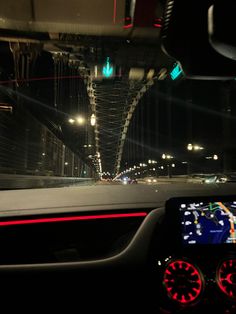 the interior of a car driving over a bridge at night