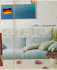 an old photo of a couch and table with flowers on it in front of a german flag