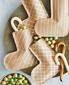 some candy canes and cookies on a plate with two christmas stocking holders in the shape of stockings