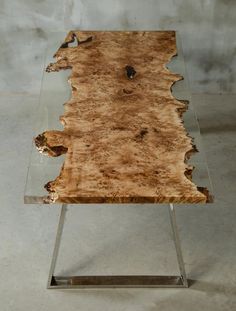 a wooden table with metal legs and a glass top that has been cut in half