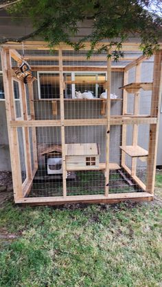 a chicken coop built into the side of a house with grass in front of it