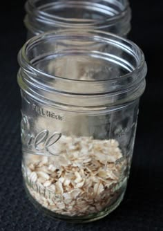 three mason jars filled with oatmeal sitting on top of a black surface