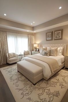 a large bed sitting in the middle of a bedroom next to a window with curtains