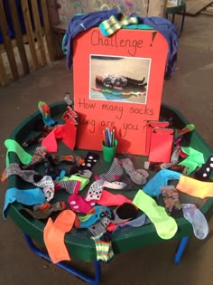 a green table topped with lots of different types of shoes and socks on top of it