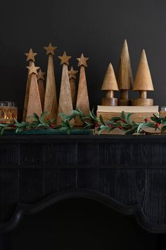 wooden christmas trees are lined up on a mantle