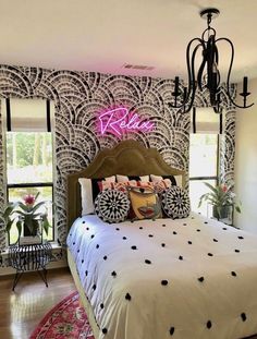 a bedroom with black and white wallpaper, chandelier and bed