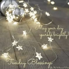 some lights that are on top of a wooden floor with the words, may your day sparkle bright