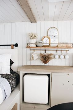 a small room with white walls and wood flooring on the wall is filled with items