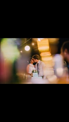 a bride and groom are kissing in front of a wedding cake with candles on it