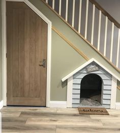 a dog house under the stairs with its door open