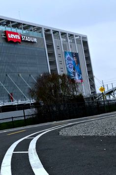 a man riding a skateboard down a curvy road next to a tall building